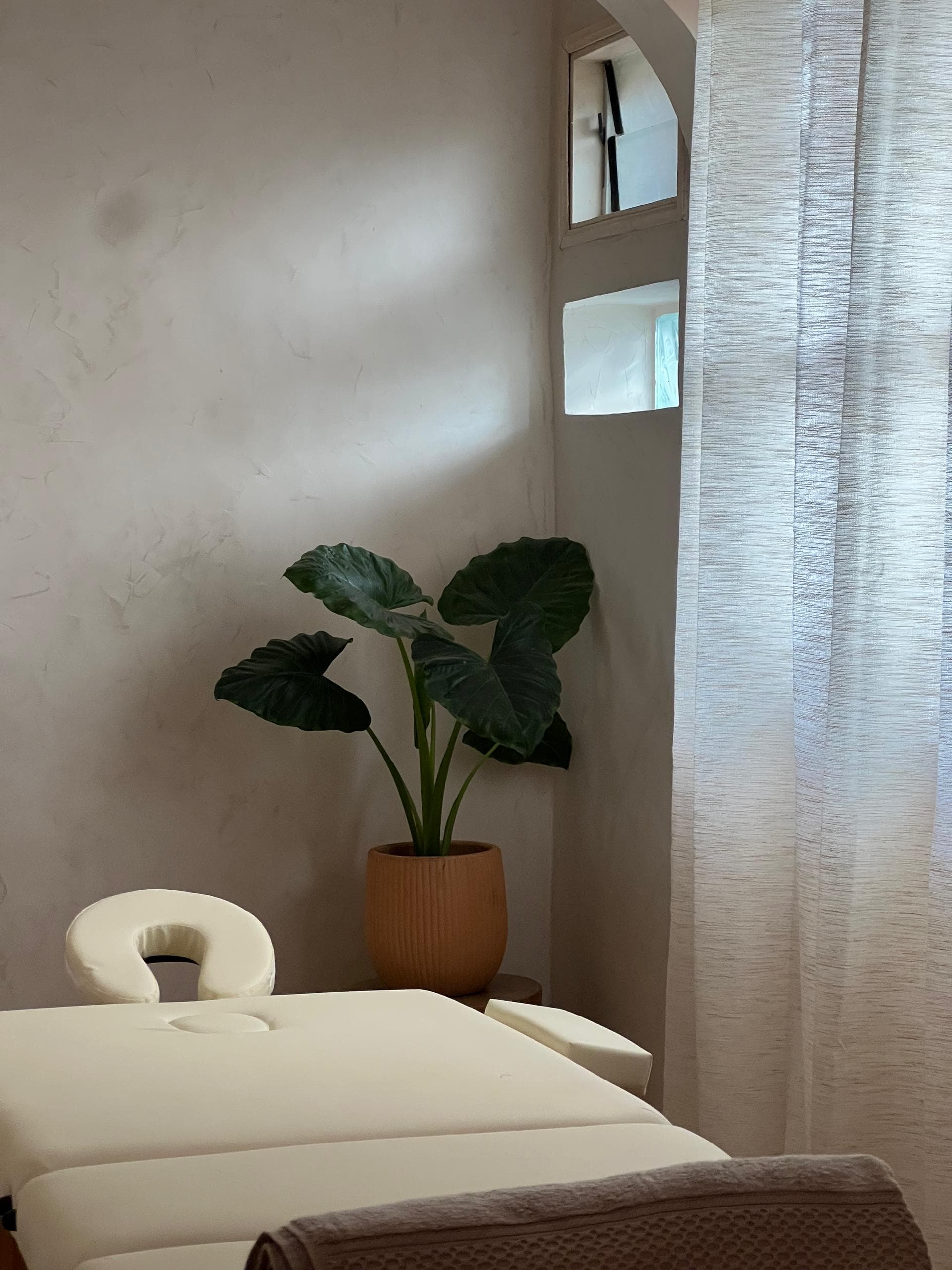 Table de massage, rideaux et plantes de l'Espace Bien-être, massage Saly
