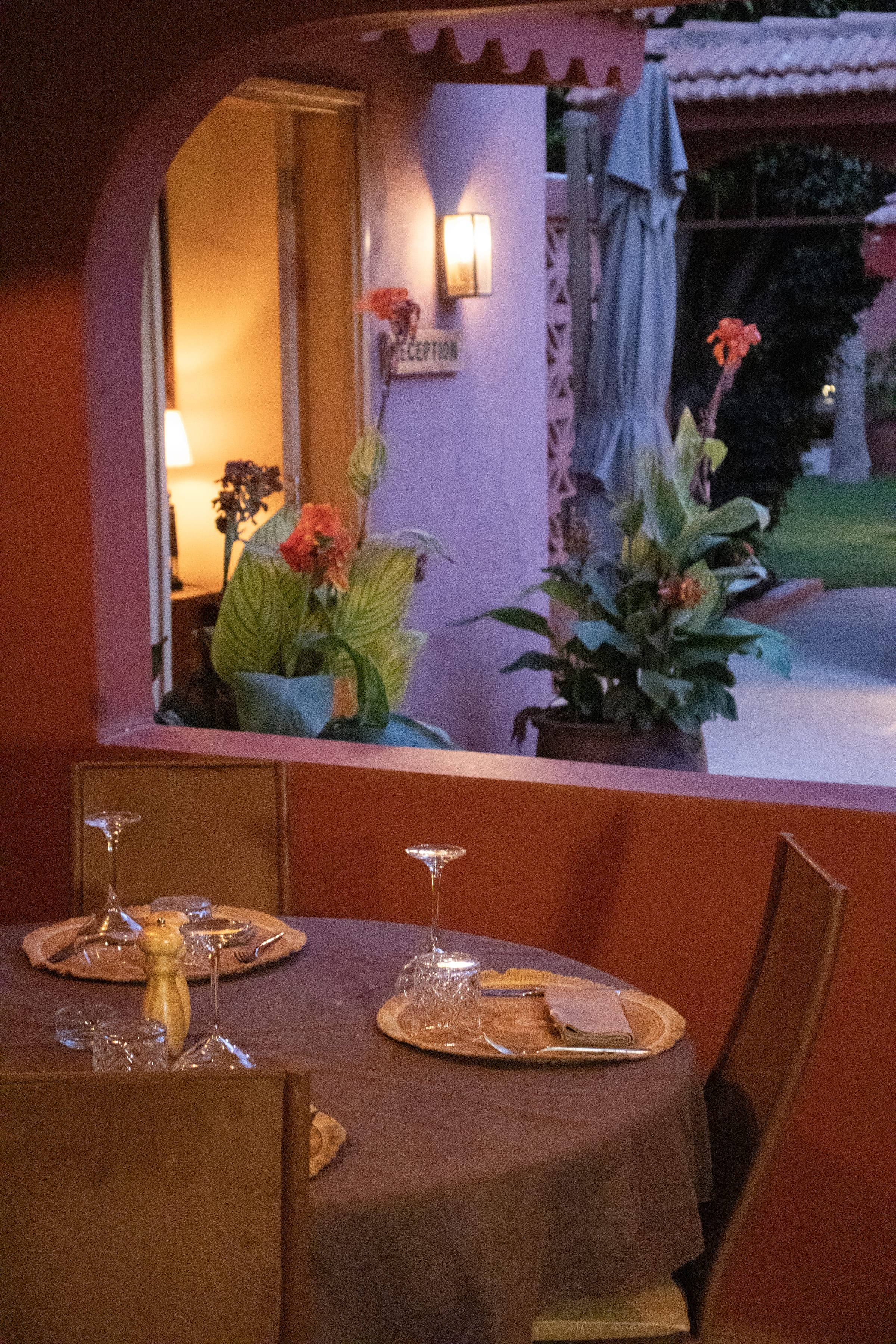 Table dressée au restaurant de Gorée Suites, ouverte sur le jardin en soirée