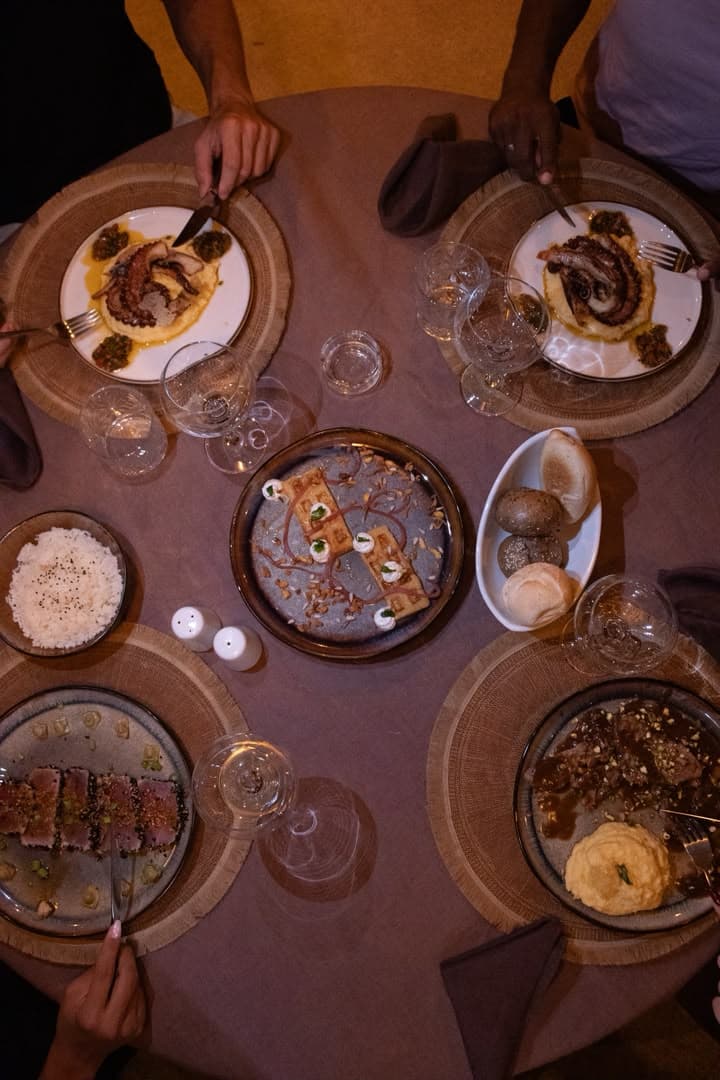 Tablée complète vue de dessus au restaurant de Gorée Suites à Saly, le soir