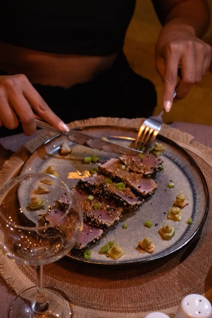Tataki de thon en croûte de sésame dégusté au restaurant de Gorée Suites, verre de vin à la main